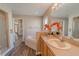 Bright bathroom features a large soaking tub, walk-in shower, and oak vanity with a large mirror at 1145 Sugar Belt Dr, St Cloud, FL 34771