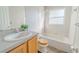 Full bathroom featuring a shower/tub combo with white tile, grey counters and wood cabinets at 1145 Sugar Belt Dr, St Cloud, FL 34771