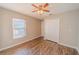 Spacious bedroom with wood floors, neutral paint, a ceiling fan, and a large window at 1145 Sugar Belt Dr, St Cloud, FL 34771
