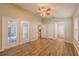 Spacious living room with wood flooring, ceiling fan, and double french doors leading to the outside patio at 1145 Sugar Belt Dr, St Cloud, FL 34771