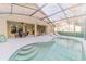 A luxurious screened-in pool featuring lounge chairs and a dining table, perfect for relaxation and outdoor entertainment at 1145 Sugar Belt Dr, St Cloud, FL 34771