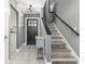 Welcoming entryway with modern gray walls, a stylish front door, and a staircase with a black handrail at 13008 Baltimore Woods Ln, Orlando, FL 32824