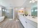 This spacious bathroom features a soaking tub, glass shower, double sink vanity and tile flooring at 13432 Beebe Aly, Orlando, FL 32827