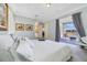 Bright bedroom featuring white linens, tray ceiling, and patio access with views of the lake at 13432 Beebe Aly, Orlando, FL 32827
