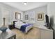 A bright bedroom featuring two windows, carpeted flooring, and a side table at 13432 Beebe Aly, Orlando, FL 32827