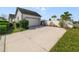 Exterior view of the home showing the driveway, garage, landscaping, and beautiful blue sky at 13432 Beebe Aly, Orlando, FL 32827