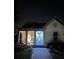 Night shot of a cozy home with a well-lit porch and blue accent front door along a brick walkway at 13432 Beebe Aly, Orlando, FL 32827