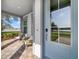 Inviting front porch with comfortable seating, views of a serene lake, and a stylish light blue front door at 13432 Beebe Aly, Orlando, FL 32827