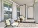 Charming front porch featuring comfortable wicker seating and large windows under a covered patio area at 13432 Beebe Aly, Orlando, FL 32827