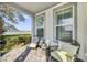 Relaxing front porch with cozy chairs and table, offering scenic lake views through large windows at 13432 Beebe Aly, Orlando, FL 32827