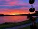 Vibrant sunset over a tranquil lake, creates a picturesque view with striking colors and serene reflections at 13432 Beebe Aly, Orlando, FL 32827