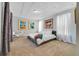 Spacious main bedroom featuring neutral carpet, tray ceilings, modern art, and large windows with sheer curtains at 13432 Beebe Aly, Orlando, FL 32827