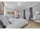 This main bedroom features neutral carpet, tray ceilings, modern art, and French doors to an outdoor space at 13432 Beebe Aly, Orlando, FL 32827