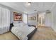 Spacious main bedroom featuring neutral carpet, tray ceilings, modern art, and an ensuite bathroom at 13432 Beebe Aly, Orlando, FL 32827
