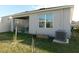 A view of the rear of the home, showing the covered patio, yard and some basic landscaping at 1360 Berry Ln, Davenport, FL 33837