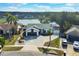 An aerial view of the home, showcasing the expansive driveway, lawn, and lake at 1410 Rena Ln, Kissimmee, FL 34744