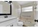 Well-lit bathroom featuring a bathtub, a sink with a black faucet, and white cabinets at 1410 Rena Ln, Kissimmee, FL 34744