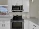 Updated kitchen boasts stainless steel appliances, white cabinets, and sleek countertops at 1410 Rena Ln, Kissimmee, FL 34744
