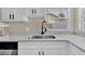Stylish kitchen featuring modern faucet, stainless steel sink, and white cabinets with black hardware at 1410 Rena Ln, Kissimmee, FL 34744