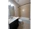 Well-lit bathroom with dark vanity, single sink, framed mirror, ceramic tiled floor, and shower-tub combination at 14257 Desert Haven St # Ge, Windermere, FL 34786