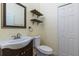 Half-bath features a vanity sink, framed mirror, and floating decorative shelves at 14637 Tanja King Blvd, Orlando, FL 32828