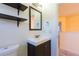 Modern bathroom vanity with a framed mirror and open view to the carpeted hallway at 14637 Tanja King Blvd, Orlando, FL 32828