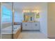Bathroom with tile flooring, white vanity with dual sinks, walk-in shower and soaking tub at 14637 Tanja King Blvd, Orlando, FL 32828