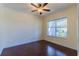 Bright bedroom with dark wood floors, a ceiling fan, and a large window providing natural light at 14637 Tanja King Blvd, Orlando, FL 32828