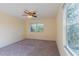Bedroom featuring a ceiling fan, carpeted floors, and natural light from large windows at 14637 Tanja King Blvd, Orlando, FL 32828