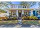 Charming two-story home featuring a covered front porch, manicured lawn, and vibrant landscaping at 14637 Tanja King Blvd, Orlando, FL 32828