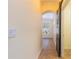Hallway with neutral walls, ceramic tile flooring and a sliding barn door leading to the foyer at 14637 Tanja King Blvd, Orlando, FL 32828