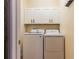 Bright laundry room with modern washer and dryer, and storage cabinets above at 14637 Tanja King Blvd, Orlando, FL 32828