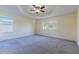 Spacious main bedroom featuring tray ceilings, neutral carpeting, and large windows for natural light at 14637 Tanja King Blvd, Orlando, FL 32828