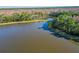 Aerial view of a large pond surrounded by lush forests and a small dock at 14637 Tanja King Blvd, Orlando, FL 32828