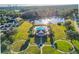 Aerial view of a community pool with a clubhouse, circular lawns, and a beautiful pond surrounded by lush greenery at 14637 Tanja King Blvd, Orlando, FL 32828