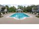Wide angle of a community pool with lounge chairs, landscaping, and a pool house at 14637 Tanja King Blvd, Orlando, FL 32828