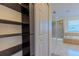 Spacious walk-in closet with dark wood shelving and access to the primary bathroom featuring a shower and soaking tub at 14637 Tanja King Blvd, Orlando, FL 32828