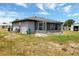 View of the gray house with screened-in porch and storage shed, set in a large yard at 152 Harrison St, Lake Wales, FL 33859