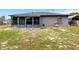 Gray house with screened-in porch and a gray block wall, situated in a spacious, partially-shaded backyard at 152 Harrison St, Lake Wales, FL 33859