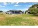 Backyard view of gray house with screened-in porch and storage shed under a blue sky at 152 Harrison St, Lake Wales, FL 33859