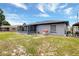 Gray home with a screened-in porch and spacious backyard, enhanced by a blue sky at 152 Harrison St, Lake Wales, FL 33859