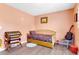 Cozy bedroom features a daybed, colorful blanket, and a wooden guitar on a blue chair at 152 Harrison St, Lake Wales, FL 33859