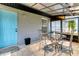 Covered patio with blue door, gray block wall, and a glass-top table with four upholstered chairs at 152 Harrison St, Lake Wales, FL 33859