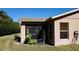 Exterior view of the home with a screened in lanai, window, and greenery at 156 Grand Canal Dr, Poinciana, FL 34759