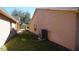 Side view of the home with a well-maintained lawn and A/C Unit at 156 Grand Canal Dr, Poinciana, FL 34759