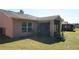 Exterior view of the home with a screened in lanai, windows, and well maintained yard at 156 Grand Canal Dr, Poinciana, FL 34759