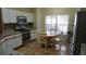 Bright kitchen with stainless steel appliances, white cabinets, and a cozy breakfast nook with a view of the yard at 156 Grand Canal Dr, Poinciana, FL 34759