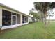 The rear of the home features a spacious screened-in lanai and lush green lawn at 185 Club Villas Ln, Kissimmee, FL 34744