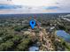 An aerial view of a neighborhood, showing the surrounding trees, roads and a pond in the distance at 206 Memphis Pl, St Cloud, FL 34769
