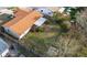 Aerial view of the backyard featuring a wooden fence, green grass, mature trees, and an attached screened patio at 206 Memphis Pl, St Cloud, FL 34769